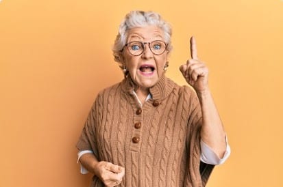 Elderly women with index finger in the air and mouth wide open