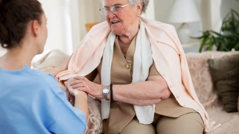 Female Care worker comforting elderly lady